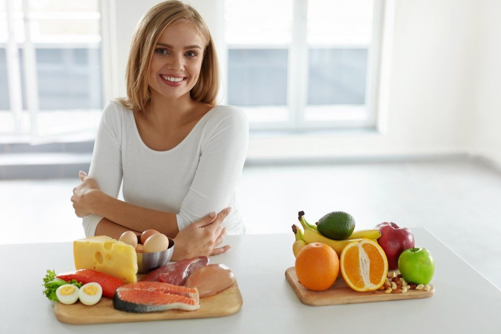 Woman sitting in the kitchen with healthy food