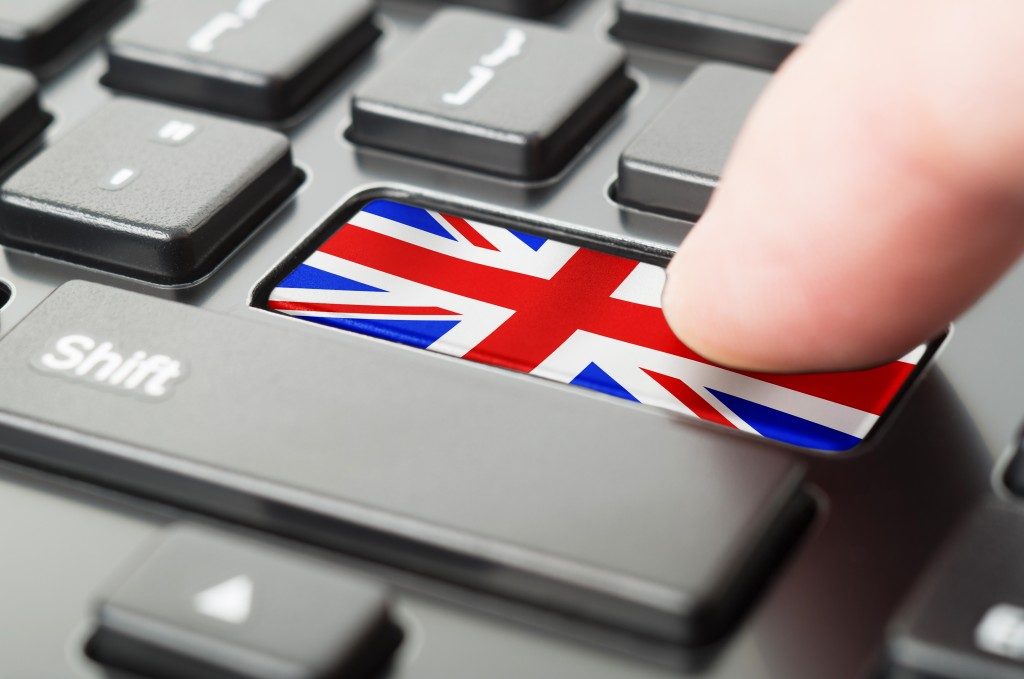 Finger pressing a UK flag on the keyboard