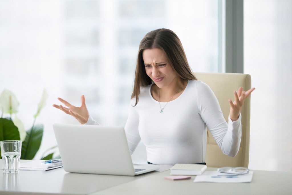 irritated woman looking at a laptop