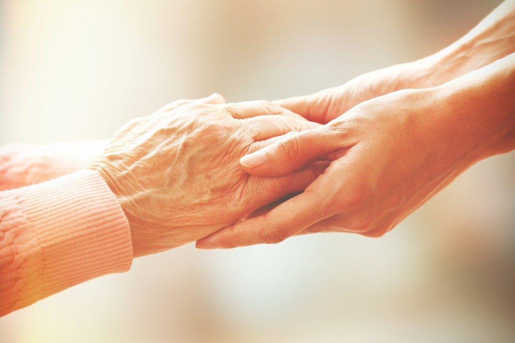 Holding an elderly woman's hand