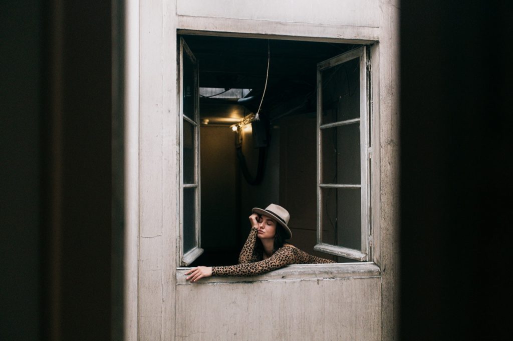 woman sticking her head out of a window due to boredom