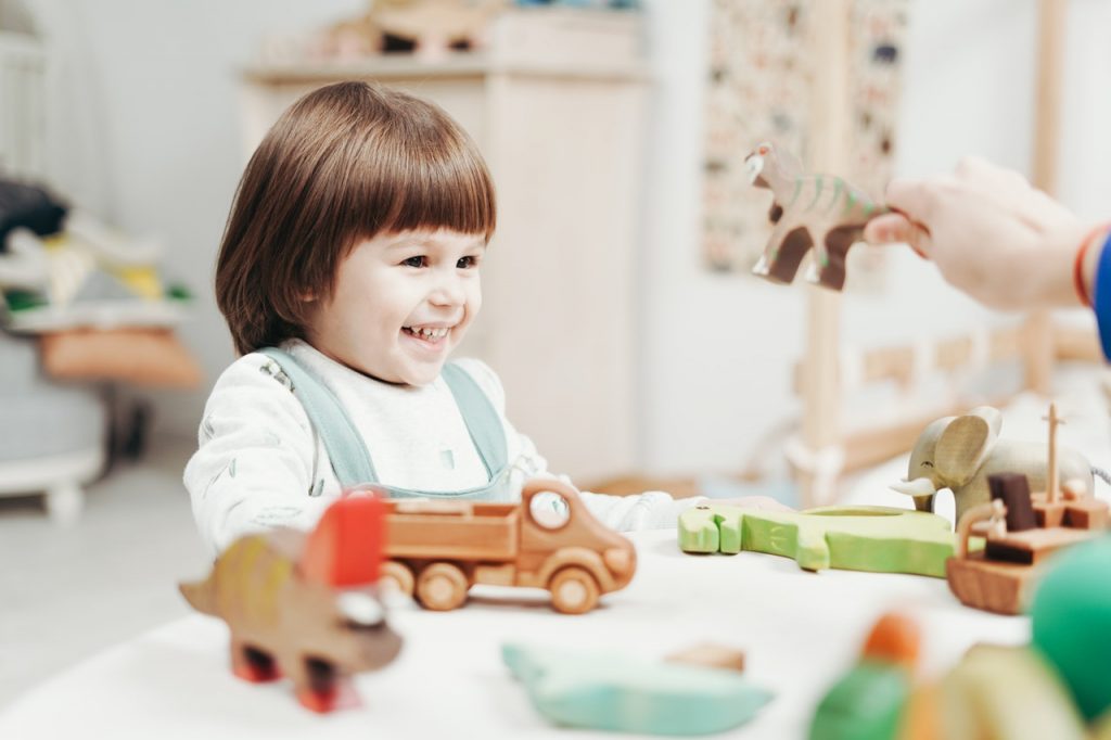 toddler smiling playing with toys