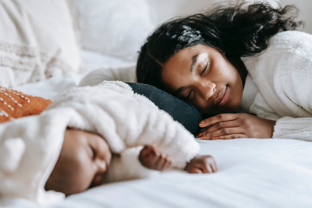 mother sleeping next to baby