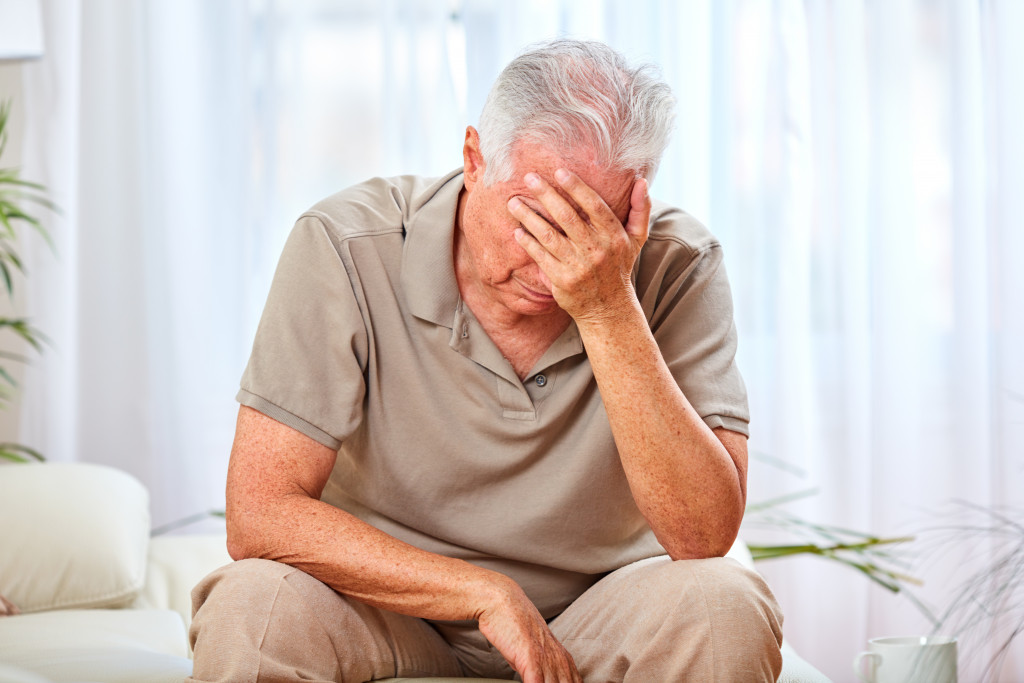 man wearing shirt crying while facepalmed