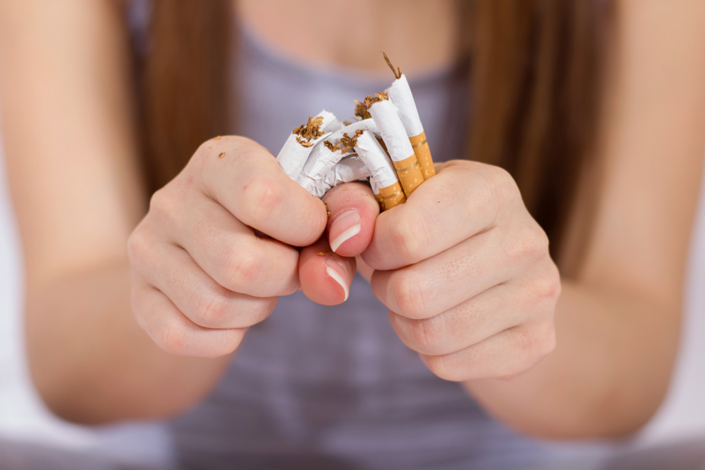 Woman breaks a bunch of cigarettes in half using her hands