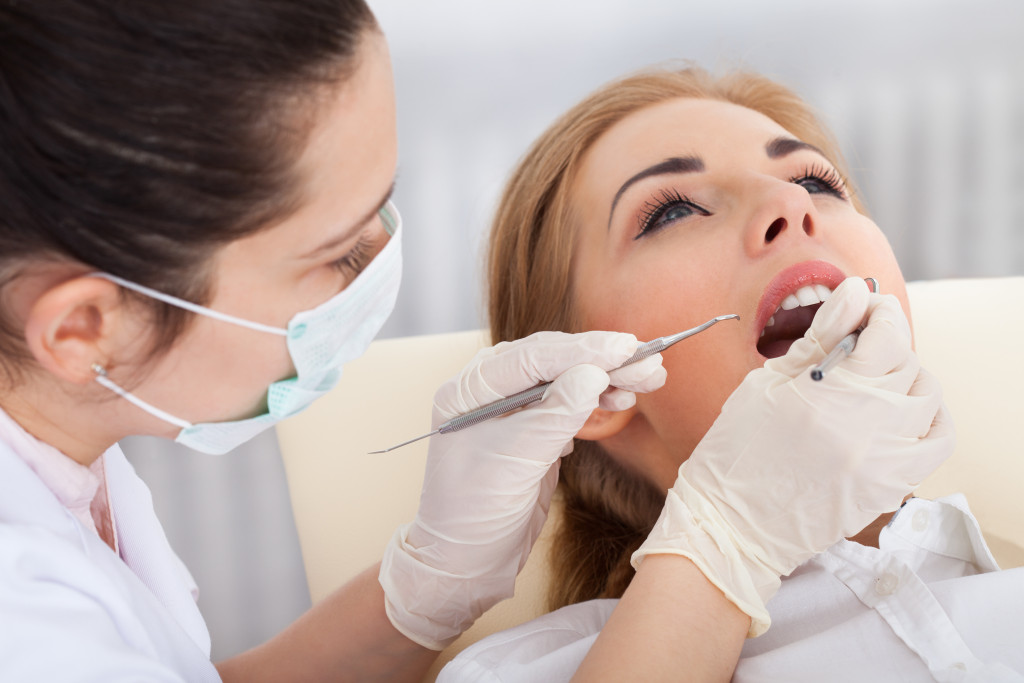 female dentist check on a female patient's teeth