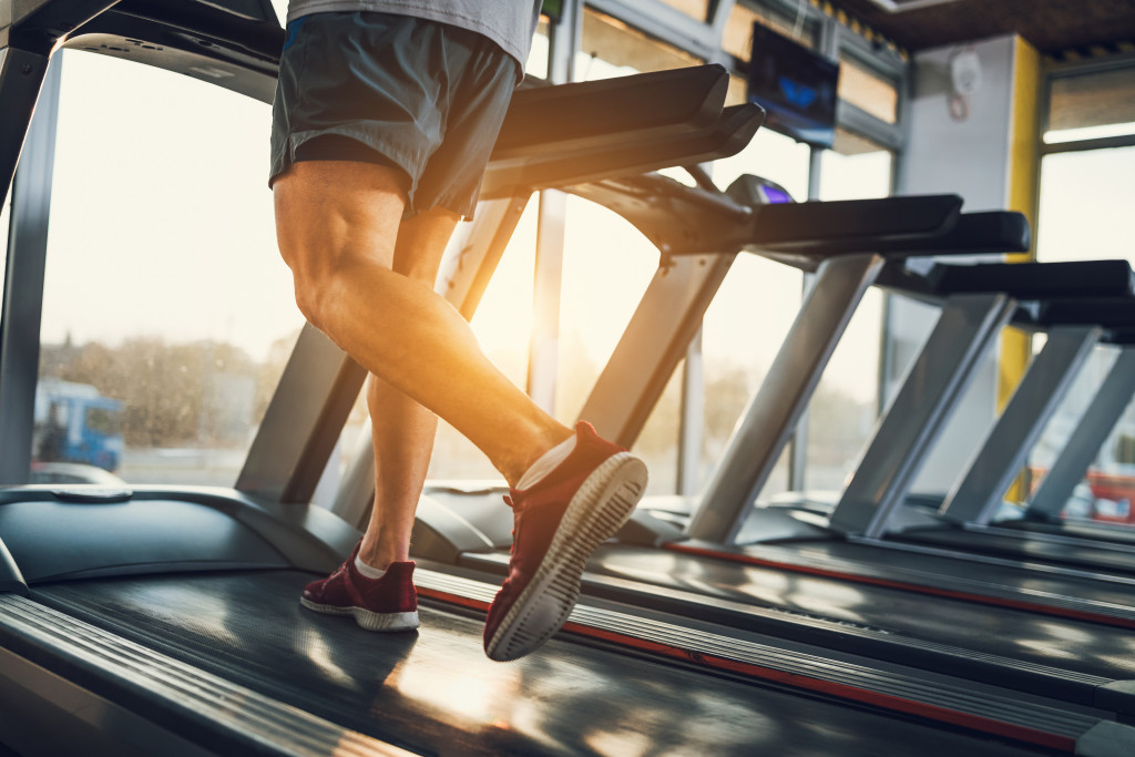 man running on a threadmill on a sunny afternoon or morning