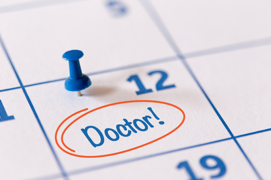 a blue calendar with a blue pin with the word doctor circled