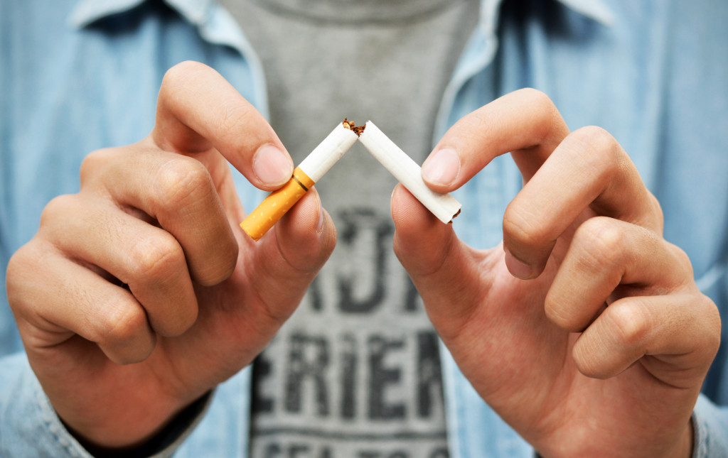 A man breaking a cigarette stick