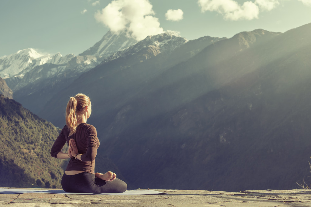 Young woman performing yoga in a mountain resort.