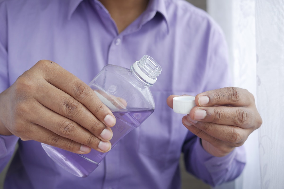 a man pouring purple liquid on a small cup