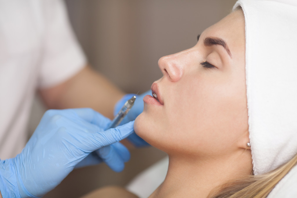 A woman getting lip fillers in a clinic