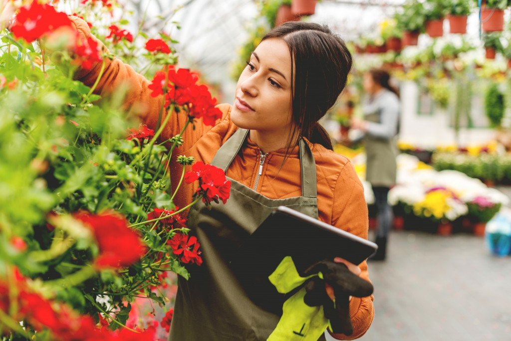 woman with her ipad looking after the flowers