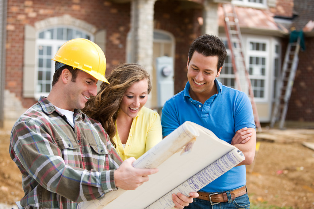 young couple looking at home plans with builder