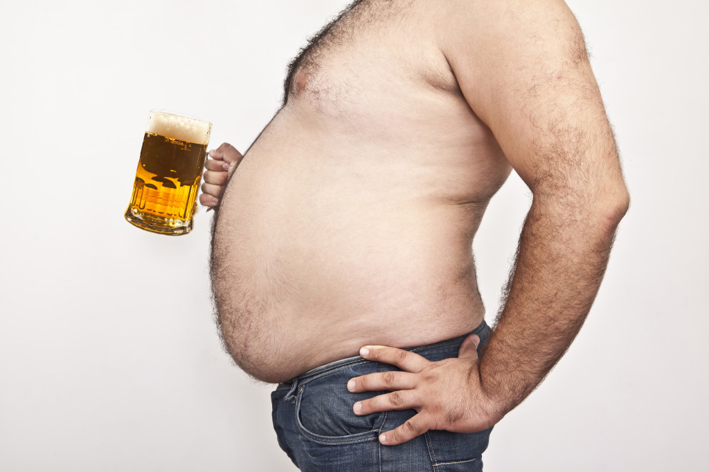 man with big tummy holding a mug of beer